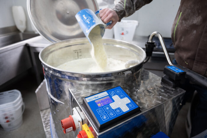 Auf diesem Bild wird dem bereits befüllten MilchTaxi eine Schaufel Milchpulver hinzugefügt.